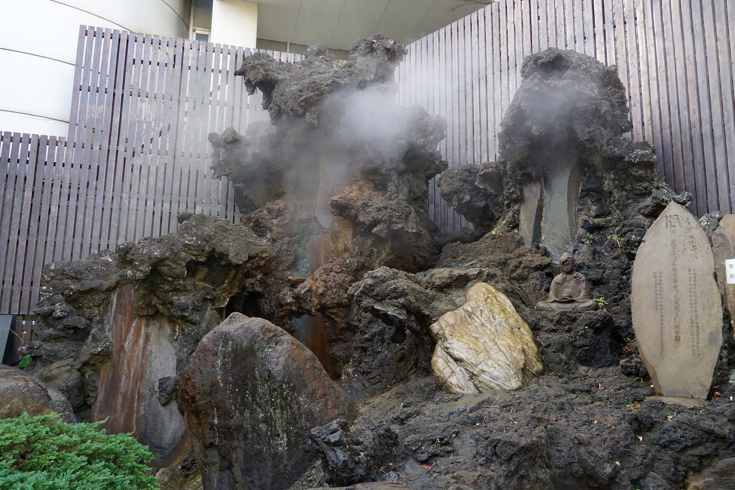 Volcanic rock formation of the Oyu geyser with drifting steam in Atami