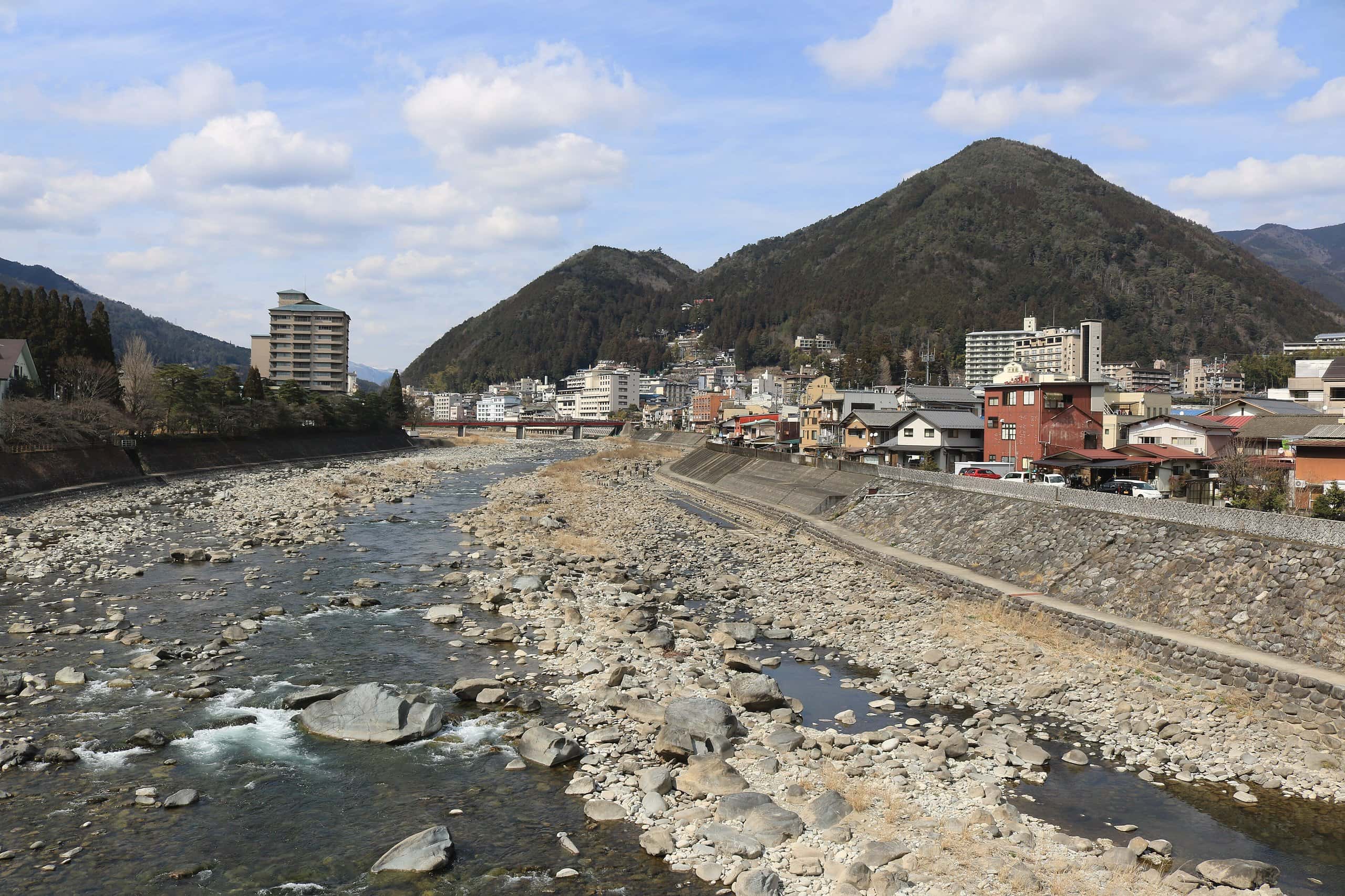 Rocky Hida River with the low-rise Gero onsen town and Mount Gero-Fuji behind