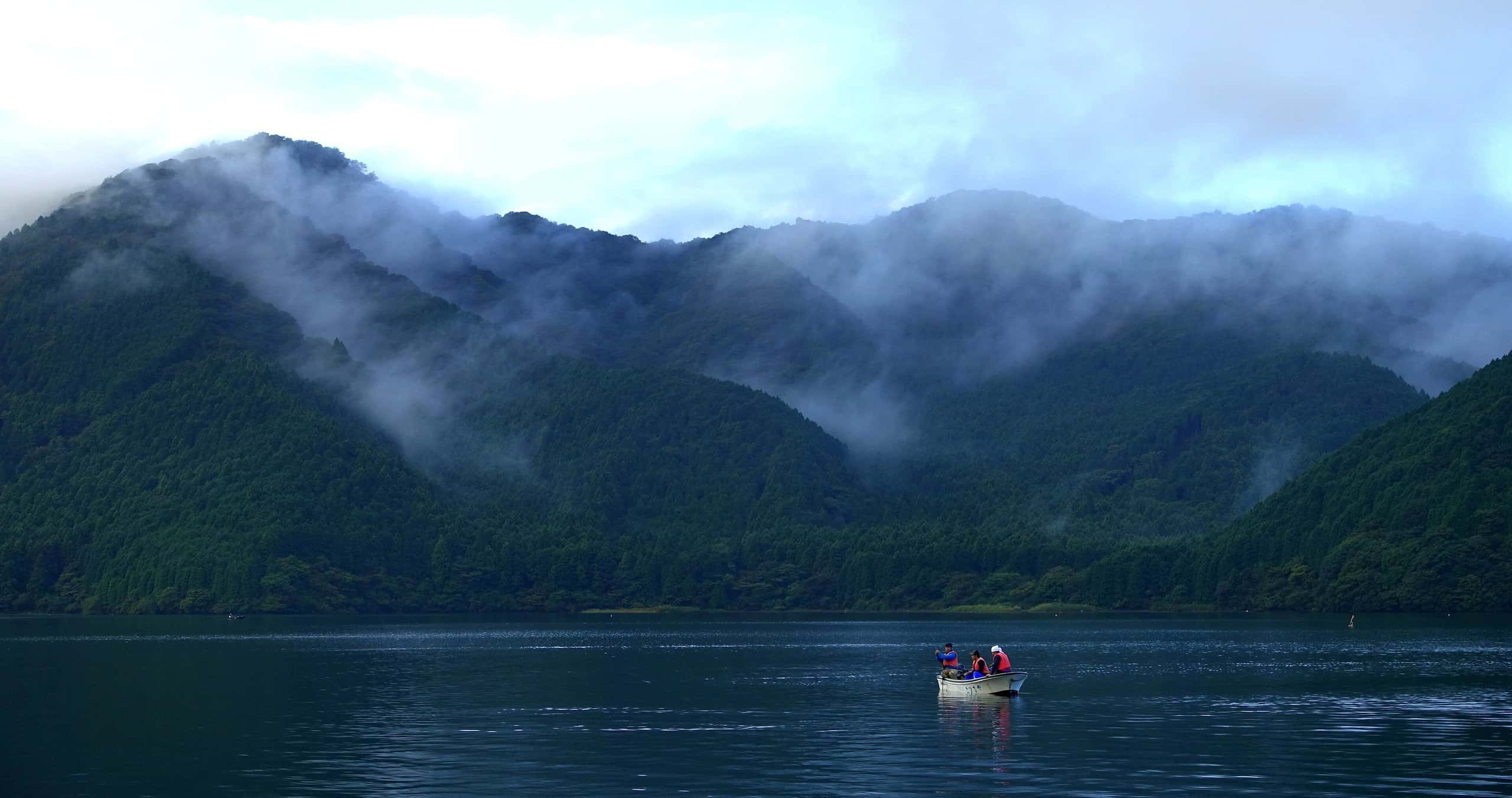 Mist drifting over forested mountains above Lake Ashi