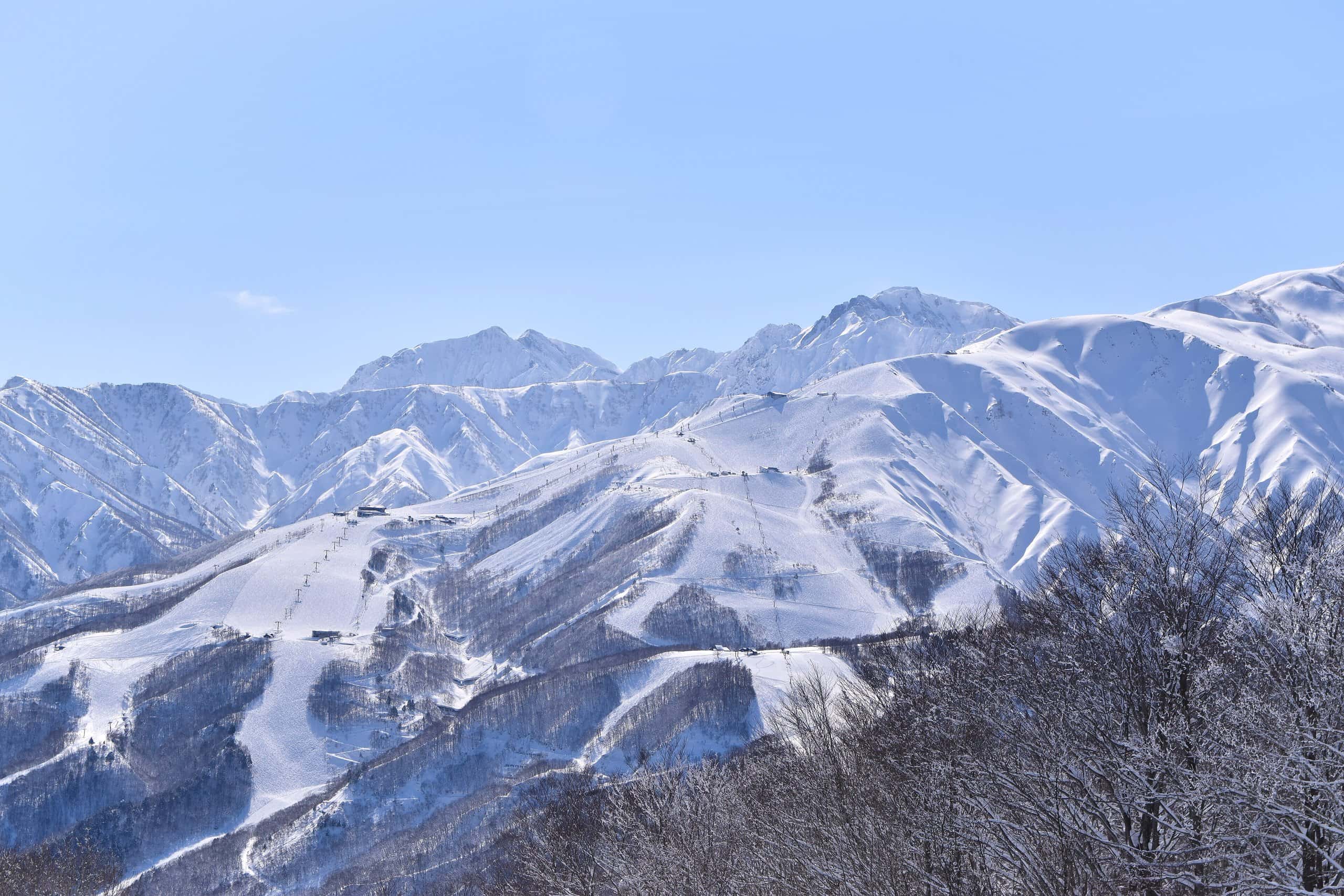 Snowy ski slopes of Happo-one beneath the jagged Northern Alps