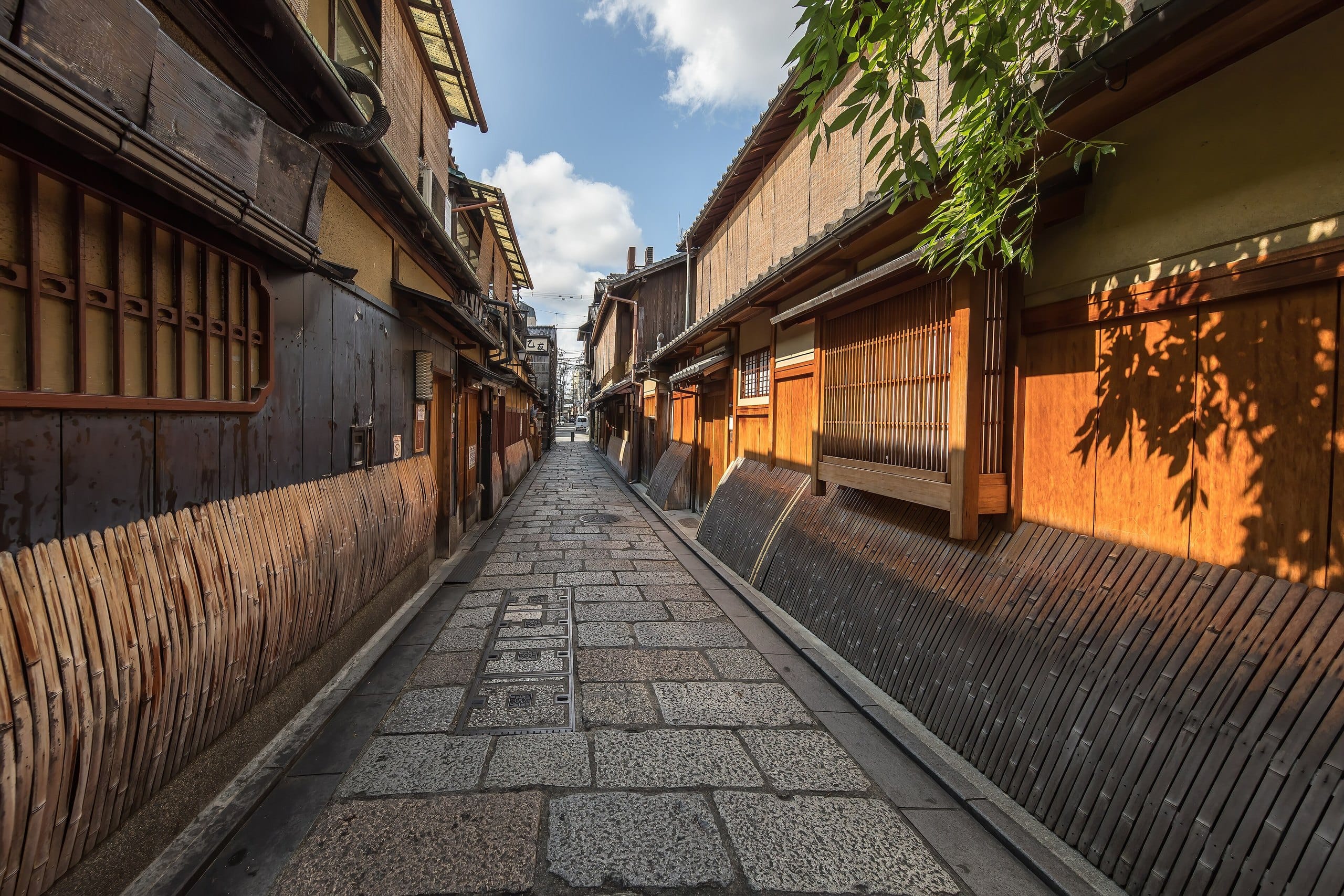 Cobbled lane lined with wooden and bamboo facades in Gion