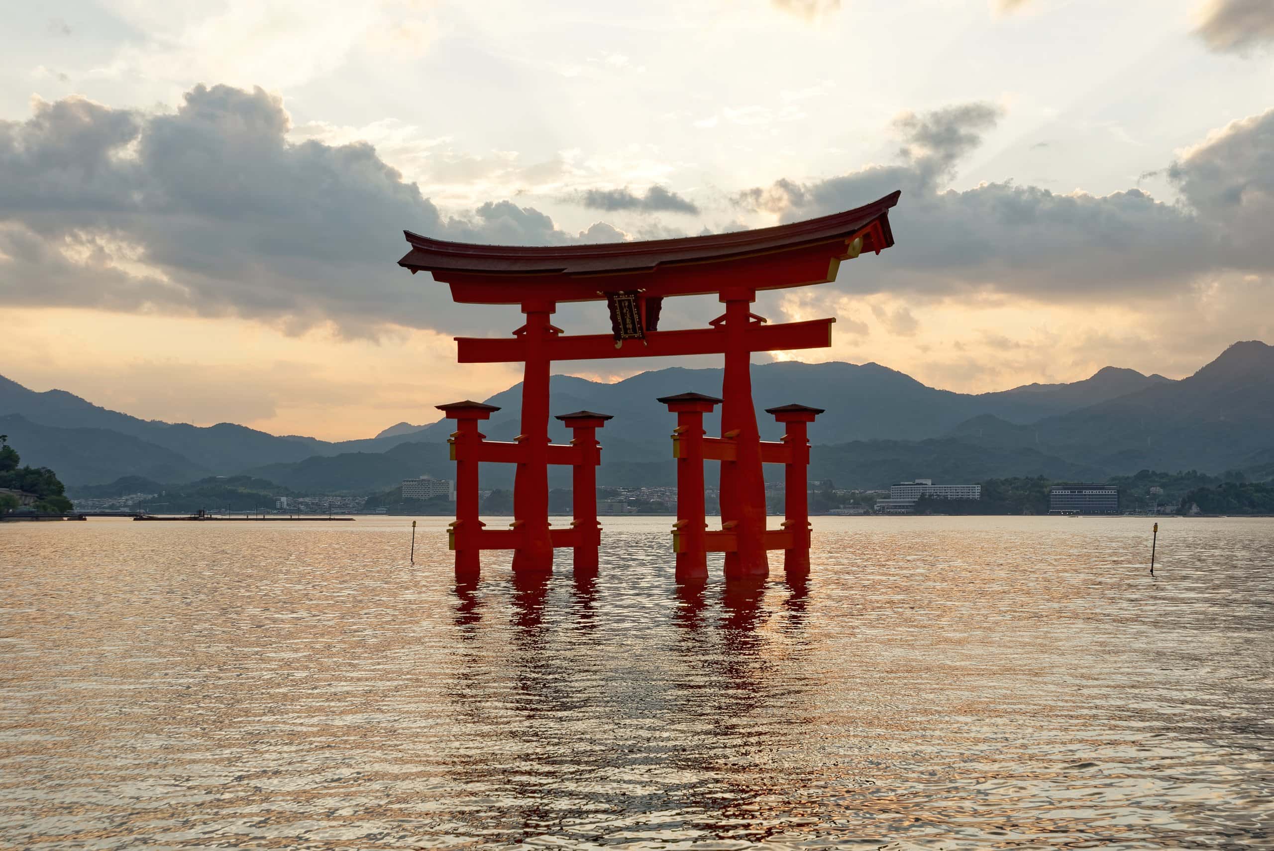 The vermilion floating torii of Itsukushima Shrine standing in the sea at sunset
