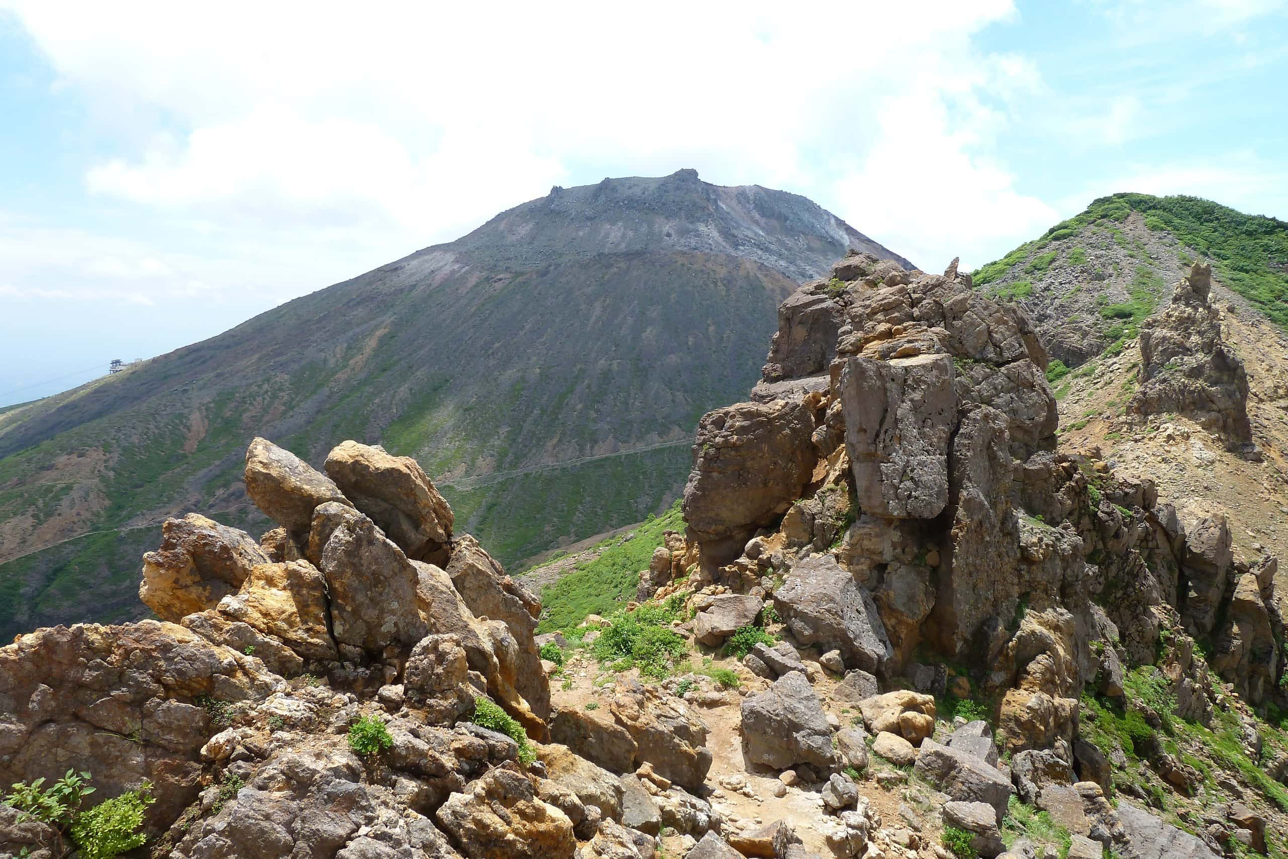 Jagged volcanic rocks in front of the summit cone of Mount Chausu