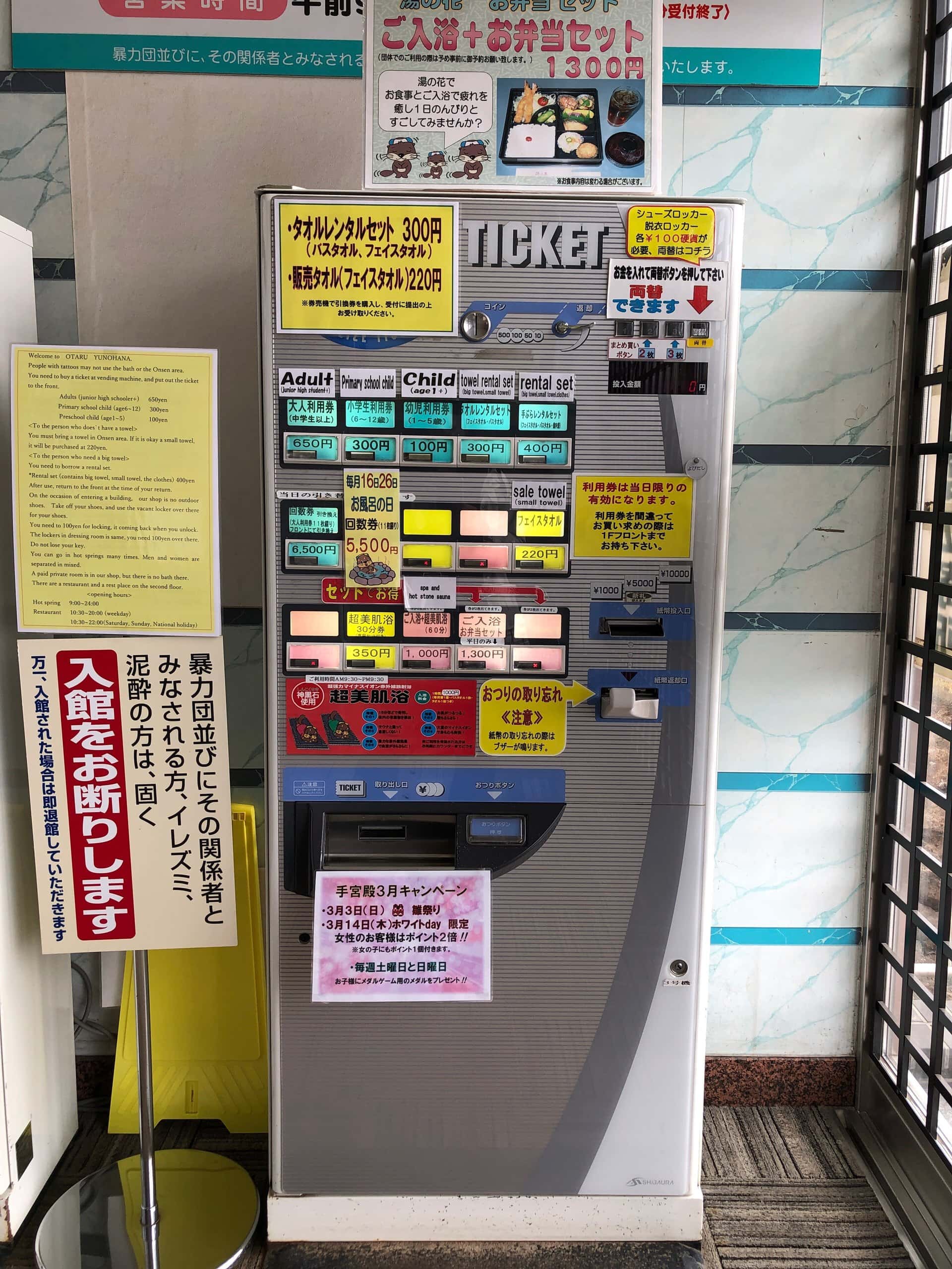 A bath-ticket machine with a standing board refusing tattooed guests