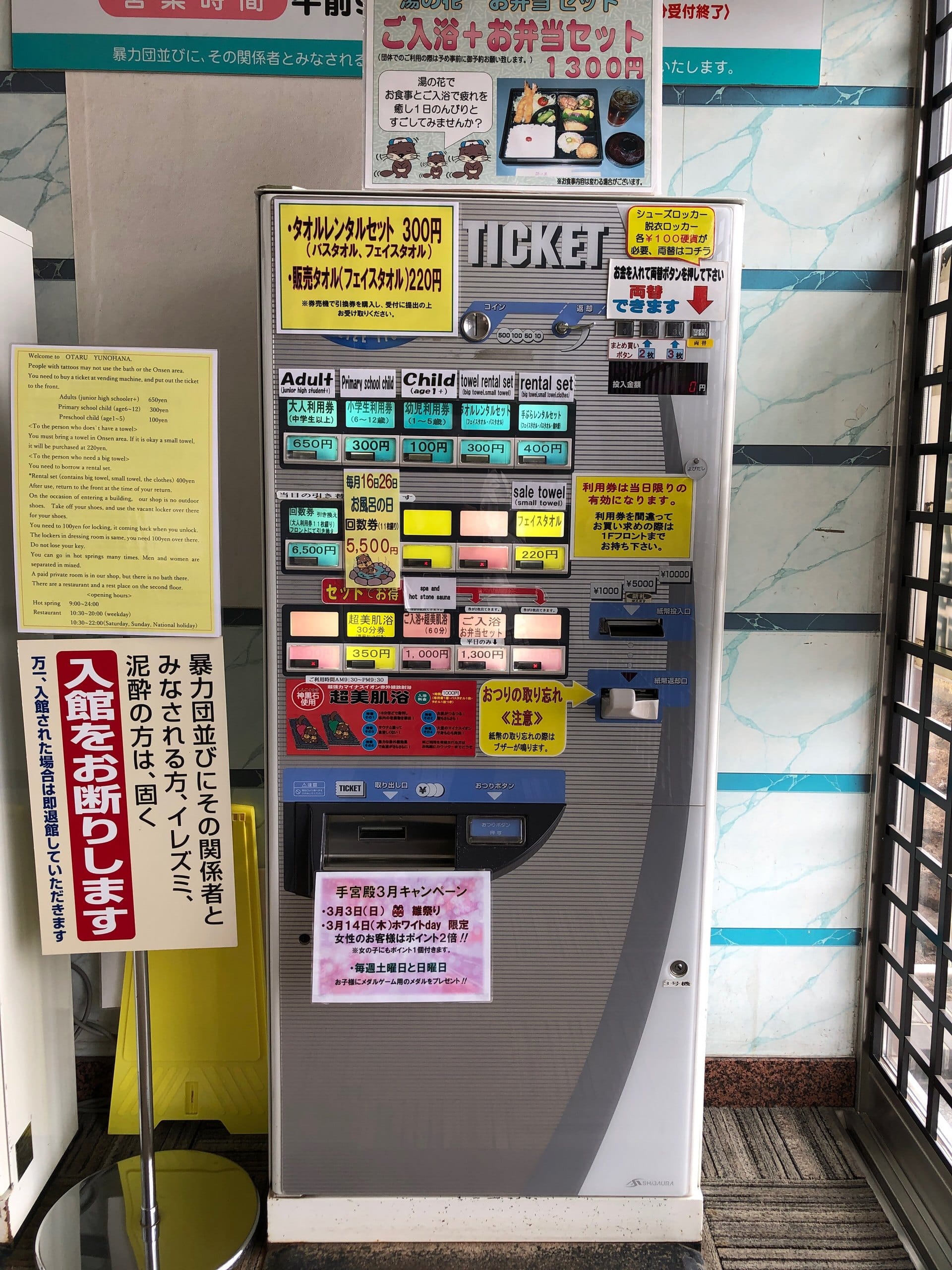 A bath-ticket machine with a standing board refusing tattooed guests