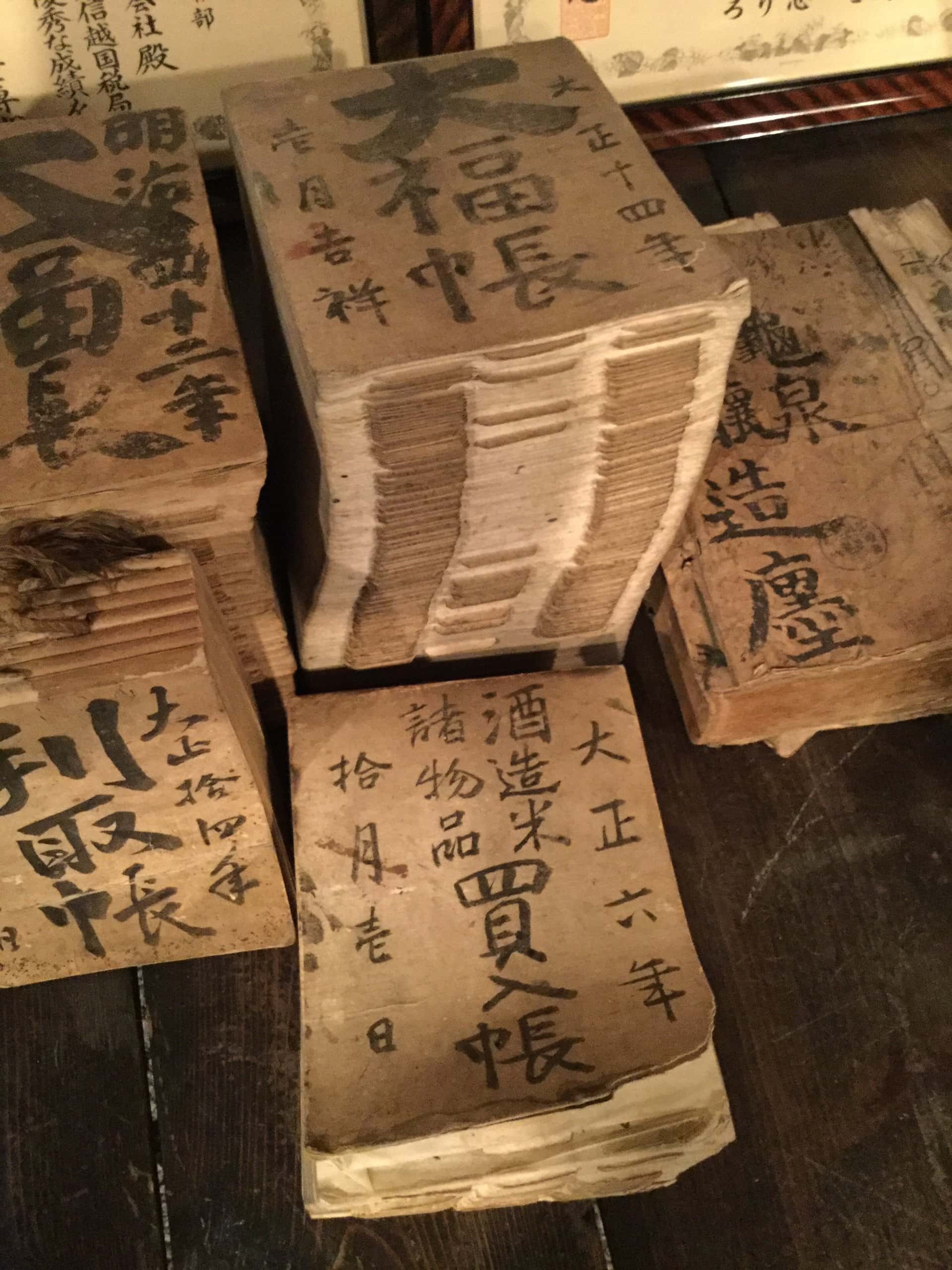 Stacks of old Japanese account books labelled in brush calligraphy