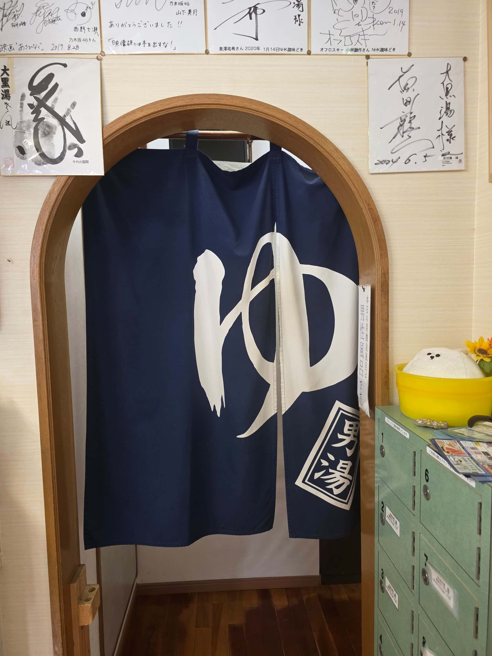 An indigo bath curtain marked with the character for hot water in an arched doorway