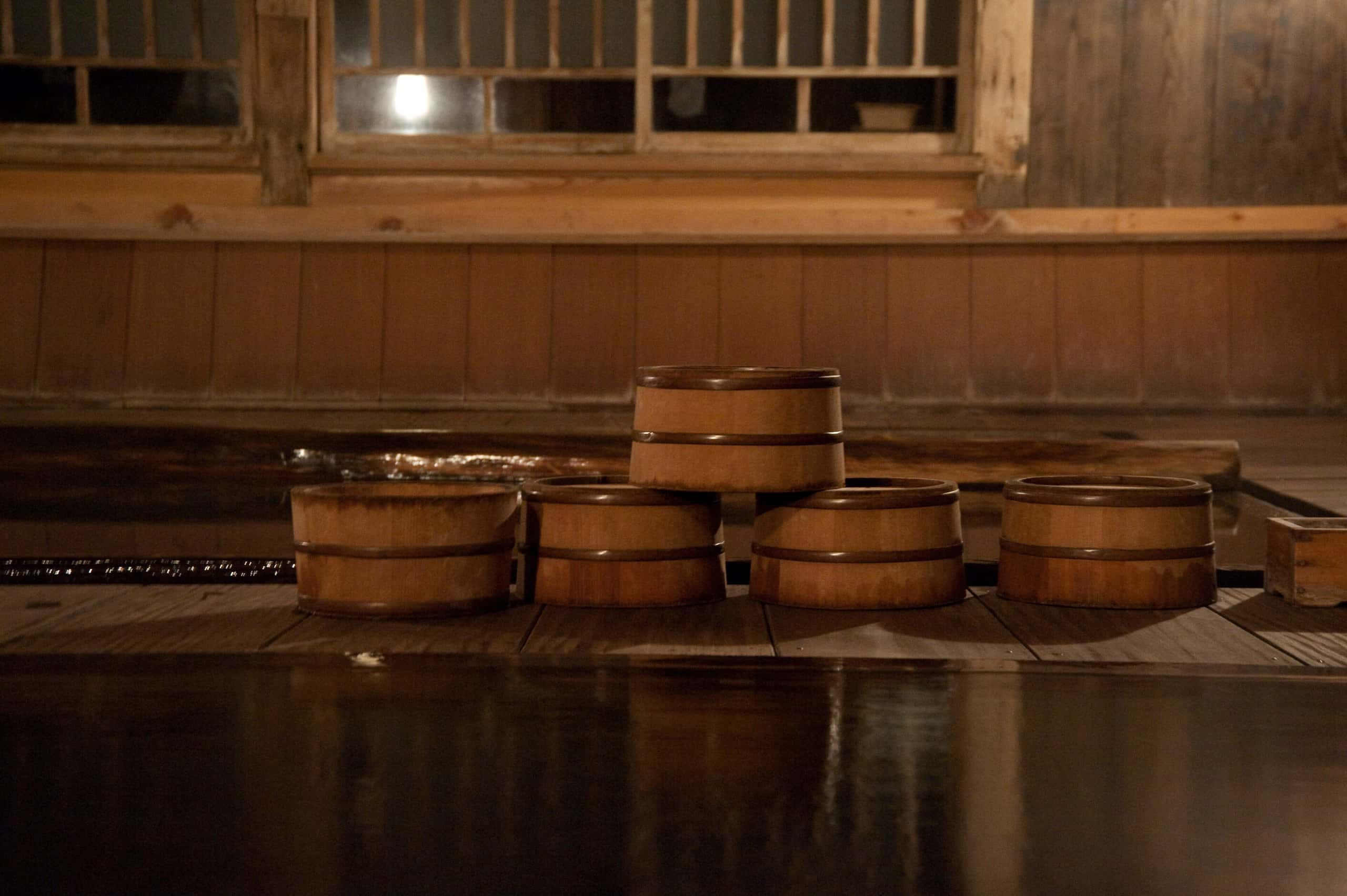Wooden bath pails stacked on the edge of an old wooden bathhouse